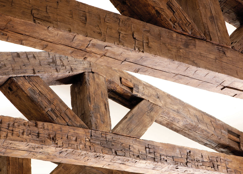 Close-up of custom reclaimed wood box beams showcasing intricate hand-hewn details and natural patina. These custom-crafted ceiling beams add rustic charm and architectural depth.