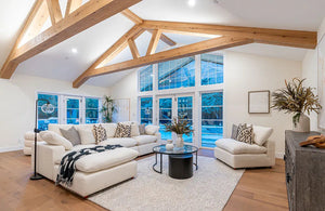 This space features reclaimed barnwood box beams, adding warmth and structure to the vaulted ceiling. The exposed ceiling beams blend rustic charm with modern elegance, creating a timeless look.